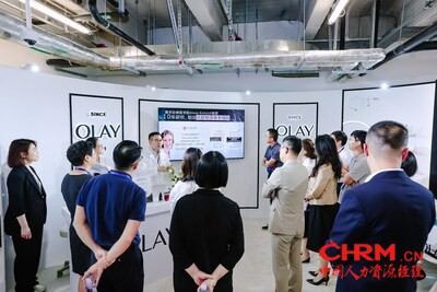 图为 OLAY 研发人员讲解新品淡纹黑管精华从根源淡化 6 大纹路